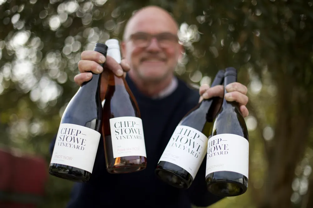 Matt Thain holding four bottles of Chepstowe wine